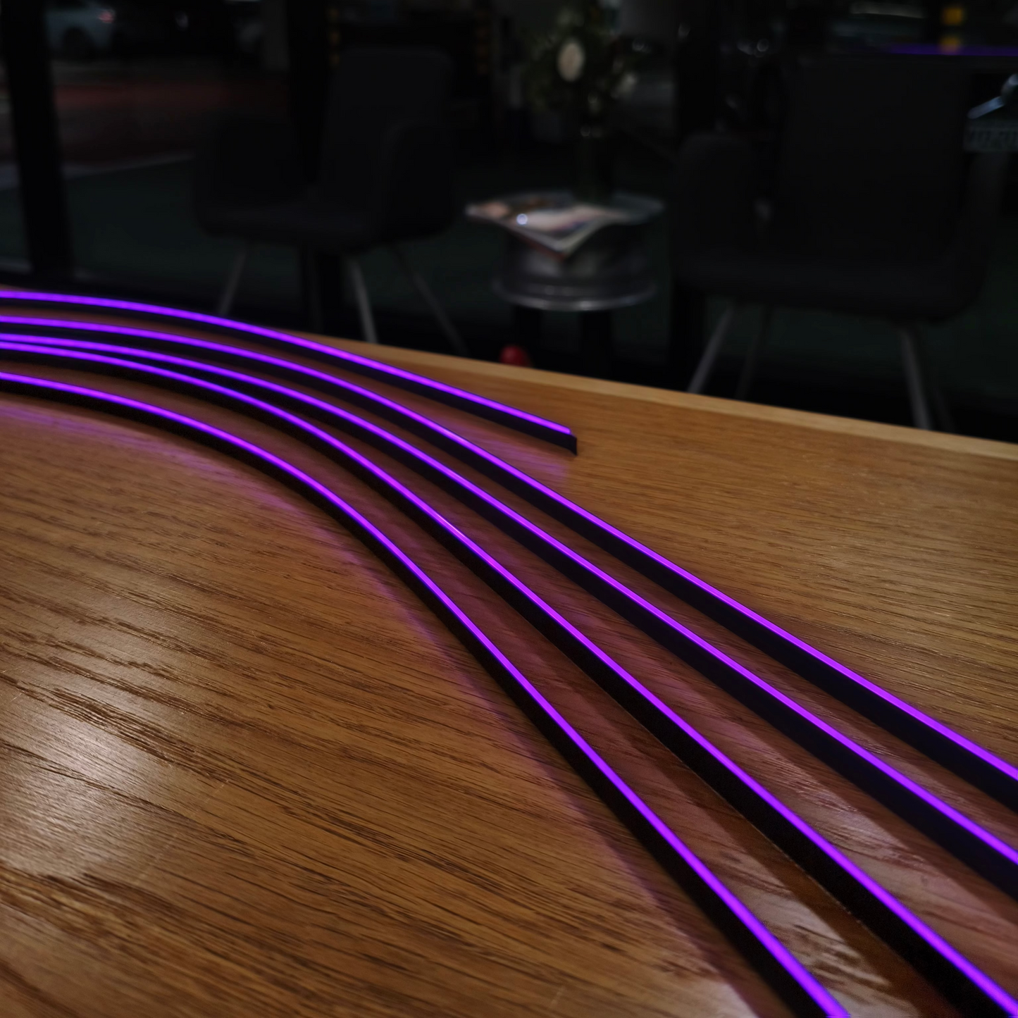 Wooden surface with purple LED strip lights in a dark indoor setting