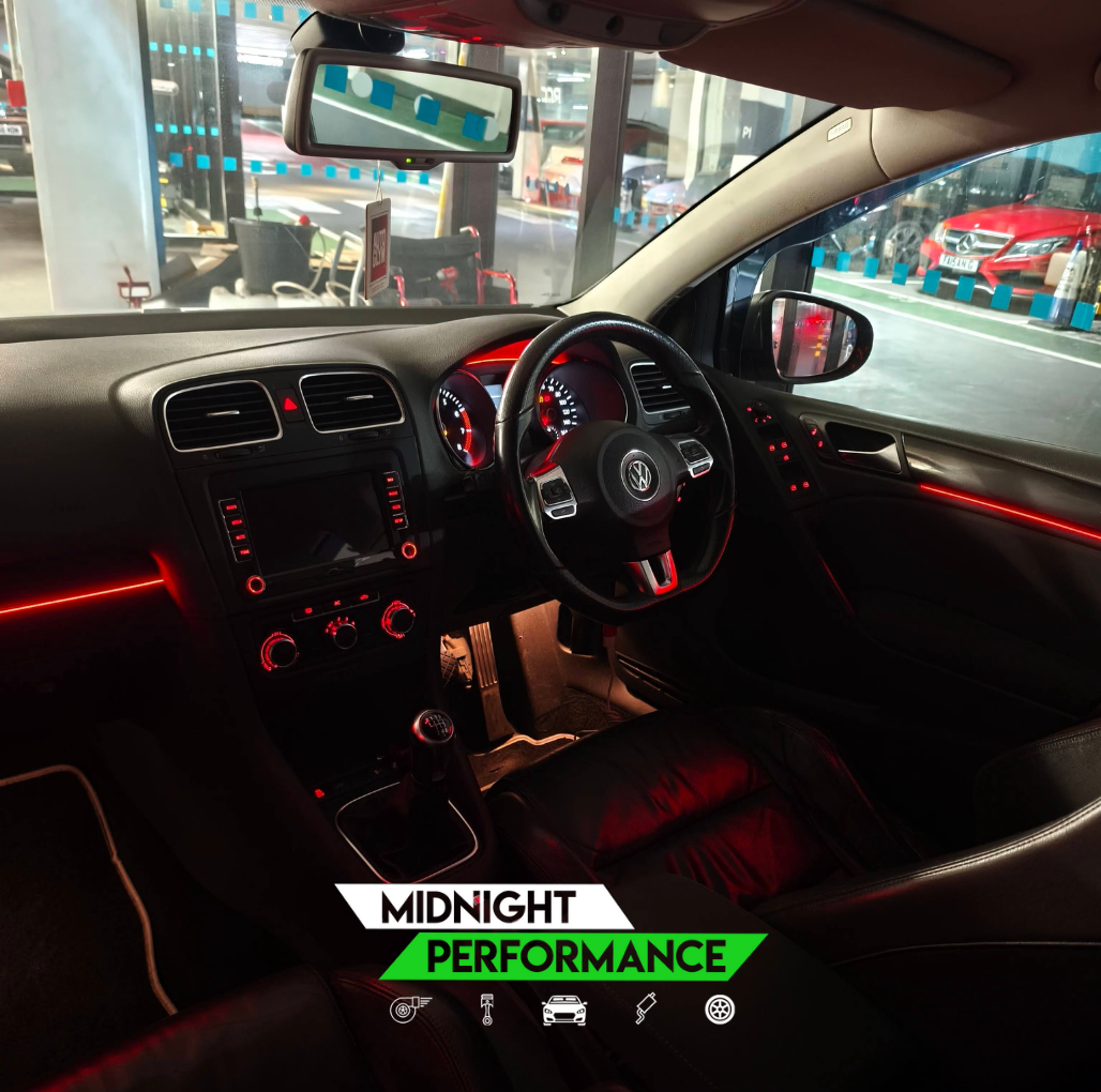 Car interior with red accent lighting in a showroom setting