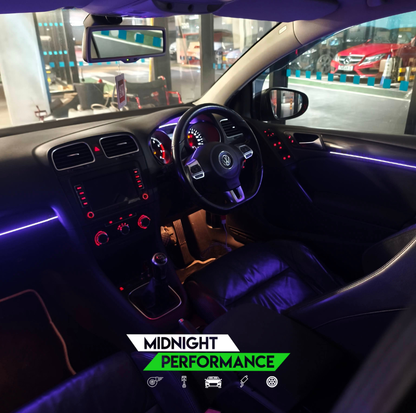 Car interior with neon lights and 'Midnight Performance' branding.