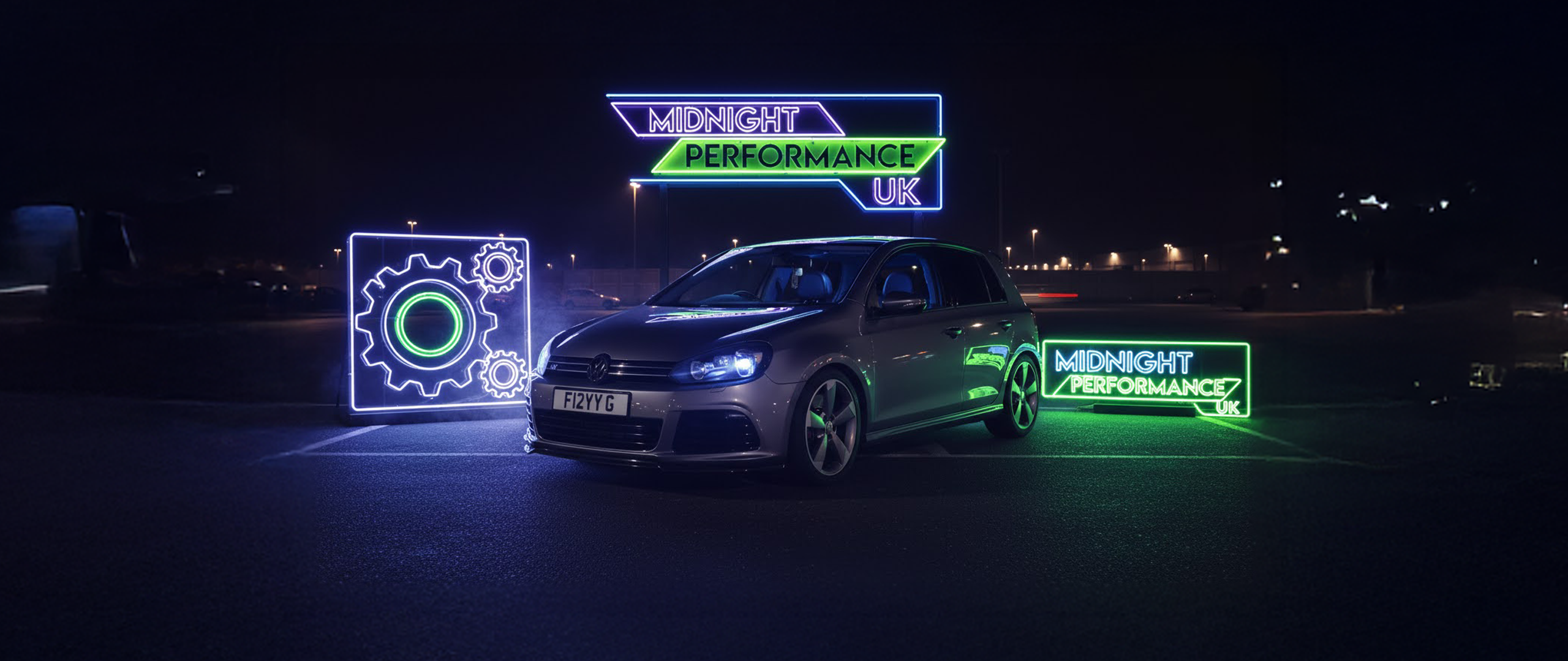 Car with neon signs and branding in a dark setting